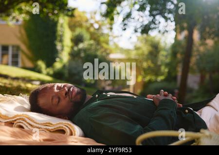 Junger Mann, der auf einer Decke im Park schläft Stockfoto