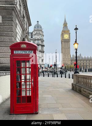 London, Großbritannien. November 2024. Eine Telefonzelle steht nicht weit vom Elizabeth Tower mit Big Ben entfernt. Eines der berühmtesten Wahrzeichen Londons ist Big Ben. Allerdings trägt nicht der Turm diesen Namen, sondern die Glocke im Turm. Der Turm selbst wird seit 2012 offiziell Elizabeth Tower genannt und steht direkt neben den Houses of Parliament. Quelle: Julia Kilian/dpa/Alamy Live News Stockfoto