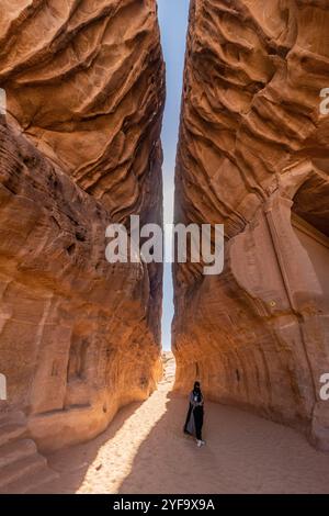 AL ULA, SAUDI-ARABIEN - 9. NOVEMBER 2021: Ortskundiger Reiseleiter in der engen Passage durch den Berg Jabal Ithlib, den Siq, bei Hegra (Mada'in Salih) in der Nähe Von A Stockfoto