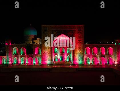 Samarkand, Usbekistan, aus der Vogelperspektive auf den farbenfrohen Registan-Platz bei Nacht. Übersetzung zur Moschee: "Ulugh Beg Madrasah und die Tilya-Kori Madrasah". Stockfoto