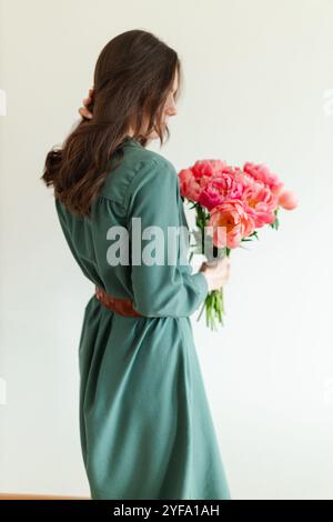 Eine junge Frau in einem blauen Kleid mit einem Blumenstrauß Stockfoto