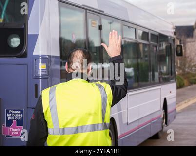 Ein Bus fährt rückwärts, während er von einem Bankmann geführt wird Stockfoto