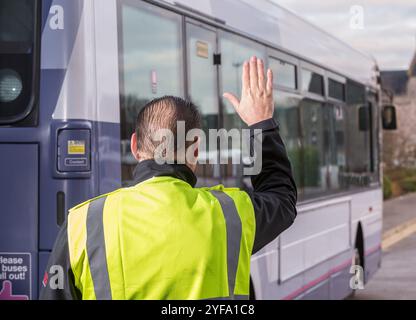 Ein Bus fährt rückwärts, während er von einem Bankmann geführt wird Stockfoto