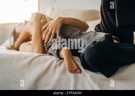 Mutter und Kind liegen zusammen auf dem Bett, childâ Fuß ist im Fokus Stockfoto