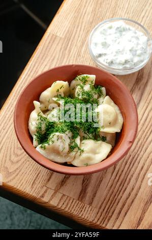 Gekochte Teigtaschen, mit Kräutern in einer Schüssel bestreut Stockfoto