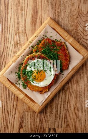 Kartoffelpfannkuchen mit Spiegelei und Kräutern Stockfoto