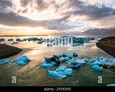 Atemberaubende Aussicht auf die Jokulsarlon Glacier Lagoon bei Sonnenuntergang mit atemberaubenden Eisbergen, die in den ruhigen Gewässern von Islands beliebtesten schwimmen Stockfoto