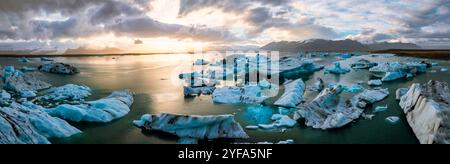 Blick aus der Vogelperspektive auf die Jokulsarlon Gletscherlagune bei Sonnenuntergang mit atemberaubenden blauen Eisbergen im ruhigen Wasser von Islands berühmtem Reiseziel. Stockfoto