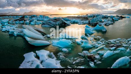 Blick aus der Vogelperspektive auf die Jokulsarlon Gletscherlagune bei Sonnenuntergang mit atemberaubenden blauen Eisbergen im ruhigen Wasser von Islands berühmtem Reiseziel. Stockfoto