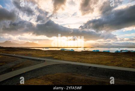 Blick aus der Vogelperspektive auf die Jokulsarlon Gletscherlagune bei Sonnenuntergang mit atemberaubenden blauen Eisbergen im ruhigen Wasser von Islands berühmtem Reiseziel. Stockfoto