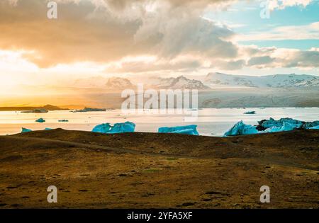 Blick aus der Vogelperspektive auf die Jokulsarlon Gletscherlagune bei Sonnenuntergang mit atemberaubenden blauen Eisbergen im ruhigen Wasser von Islands berühmtem Reiseziel. Stockfoto