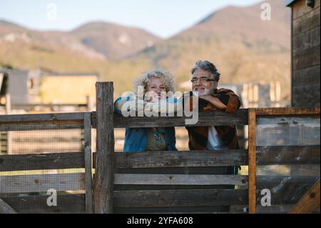Ein glückliches und entspanntes Paar mittleren Alters, das sich auf einer Farm amüsiert Stockfoto