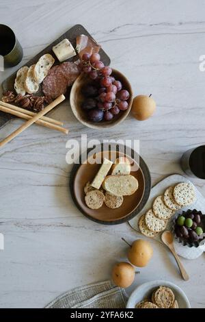 Wurstwaren mit Trauben, Käse, Nüssen, Crackern und Birnen auf einem Tisch Stockfoto