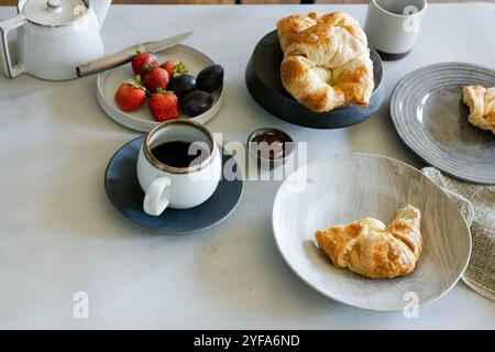 Frühstück mit Kaffee, Croissants, Erdbeeren und Marmelade Stockfoto