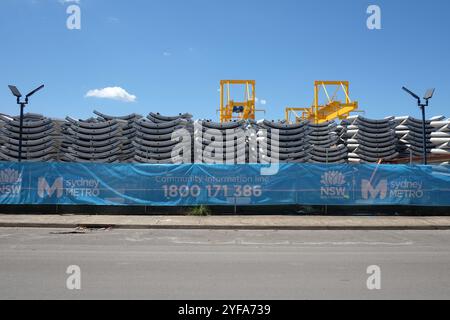 Stapel gekrümmter Betonfertigteile für den Tunnelbau und gelbe Portalkrane im Sydney Metro Depot in Sydenham Stockfoto