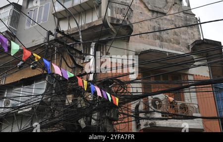 Unordentlicher verwickelter Strom, Telekommunikationsdrähte, Kabel an Masten in Hanoi, Vietnam, Asien Stockfoto