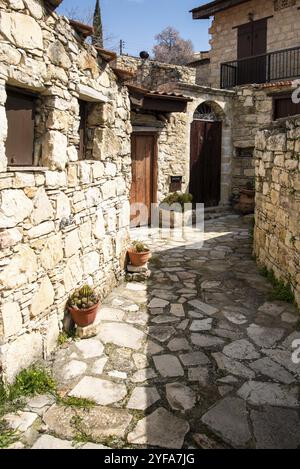 Steiniger Fußweg durch ein traditionelles Dorf. Steinige Häuser mit Holztüren. Vintage-Architektur. Dorf Lofou, Zypern, Europa Stockfoto