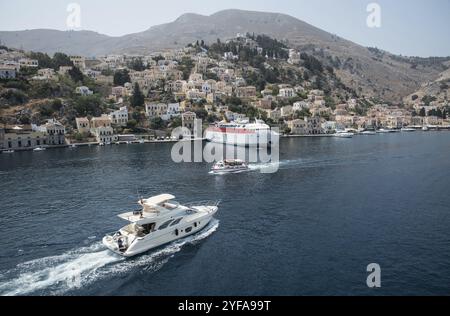 Symi, Griechenland, 1. August 2016: Panoramaaufnahme der Stadt Symi mit dem Hafen und Luxusyachten auf der griechischen Insel Symi an der Ägäis, Europa Stockfoto