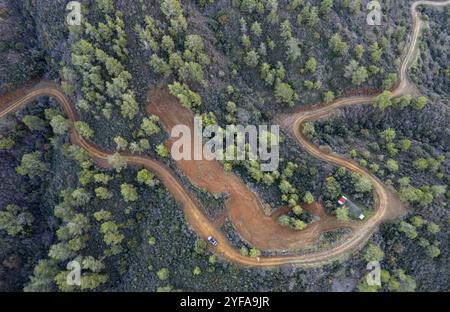 Drohnenantenne einer ländlich gekrümmten Straße, die durch den Berg führt. Entdeckungen und Abenteuer in der Natur. Troodos Zypern Stockfoto