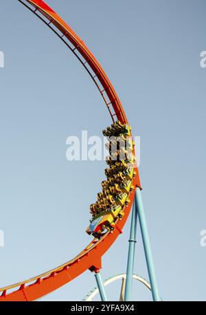 Barcelona, Spanien- 3. August 2012: Jugendliche auf einer extremen Achterbahnfahrt im berühmten Vergnügungspark Port Aventura vor einem blauen Himmel in Barcelona Stockfoto