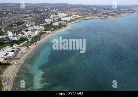 Luftaufnahme der Küste mit organisiertem Strand, Ayia Napa, Zypern. Drohnenlandschaft der goldenen Sandküste mit Sonnenliege und Sonnenschirmen Stockfoto