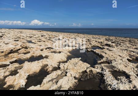 Felsige Küste im Ozean vor blauem bewölktem Himmel. Cape Greko, Protaras Zypern Stockfoto