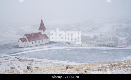 Die malerische Vik i Myrdal Kirche auf der Spitze des Hügels bei starkem Schnee im Dorf vik in Island im Winter Stockfoto