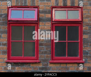 Traditionelle rote, englische Metallfenster an einer gemauerten Wand Stockfoto