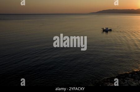 Luftdrohnenansicht eines Fischerbootes, das im Meer segelt, um bei Sonnenaufgang Fische zu fangen. Latsi Paphos Zypern Stockfoto