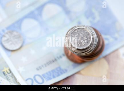 Fünf Pence englische Silbermünze auf einem Stapel Münzen und Euro-Banknoten Stockfoto