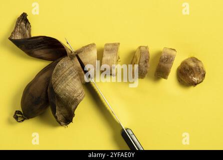 Scheiben fauler ungesunder Banane auf gelbem Hintergrund Stockfoto