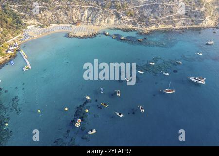 Drohnen-Luftlandschaft mit Luxusyachten, die an der Küste festgemacht sind, und unerkannten Menschen, die schwimmen und entspannen. Sommerurlaub im Meer. Konnos Bay Ay Stockfoto