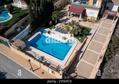 Luftdrohnenfoto einer wunderschönen Villa in der Stadt Benidorm in Spanien, das das zweistöckige spanische Haus mit einem Swimmingpool an einem heißen Tag in der zeigt Stockfoto