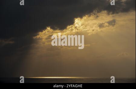 Sonnenaufgang im Meer mit stürmischen Wolken und oranger Farbe. Seascape am Morgen. Sonnenstrahlen im Meer Stockfoto