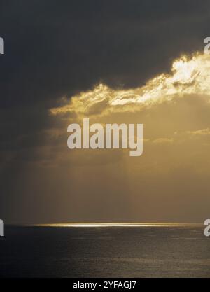 Sonnenaufgang im Meer mit wolkenstürmischen Wolken und oranger Farbe. Seascape am Morgen. Sonnenstrahlen im Meer Stockfoto