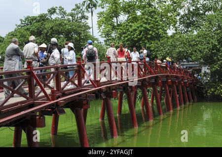 Hanoi, Vietnam, 3. August 2010: Vietnamesen gehen auf der roten Huc-Brücke, die zur Insel Jade führt. Hanoi, Vietnam, Asien Stockfoto