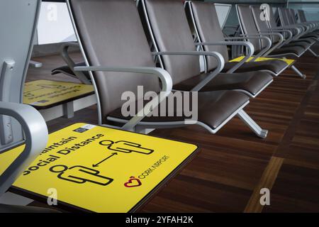 Cork, Irland, 10. September 2021: Gelbes Zeichen für soziale Distanz auf den Terminalstühlen am Flughafen Cork. Sicherheitsmaßnahmen vor der covid-19-Pandemie, Europa Stockfoto