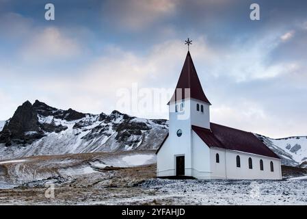 Die malerische Vik i Myrdal Kirche auf dem Gipfel des Hügels bietet malerische Bilder des atlantischen Ozeans und des Dorfes vik in Island Stockfoto