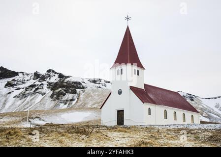 Die malerische Vik i Myrdal Kirche auf dem Gipfel des Hügels bietet malerische Bilder des atlantischen Ozeans und des Dorfes vik in Island Stockfoto