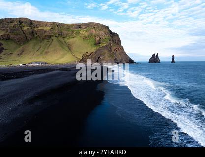 Blick aus der Vogelperspektive auf den schwarzen Sandstrand von Reynisfjara und die Meeresstapel in Island. Stockfoto
