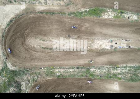 Drohne eines Motocross-Rennens auf einer kurvenreichen Sportstrecke. Luftaufnahme von Hochgeschwindigkeitsrennen. Athleten in Aktion Stockfoto