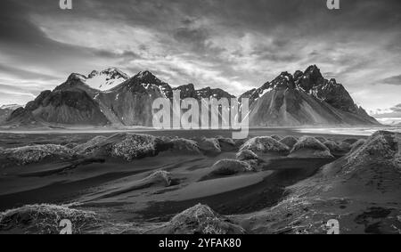 Schwarz-weiß-Bild der isländischen Landschaft Südisland, Hofn, Stokksnes Halbinsel mit den berühmten Vestrahorn Bergen und dramatischem Himmel Stockfoto