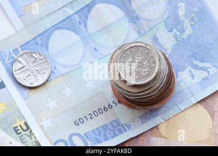 Britische fünf-Silber-Pence-Münze auf einem Stapel Münzen und 20 Euro-Banknoten Stockfoto