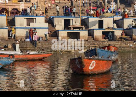 Varanasi, Indien, 13. März 2017: Holzboote am IAT-Ufer des heiligen Ganges am Morgen. Indianer baden, Asien Stockfoto