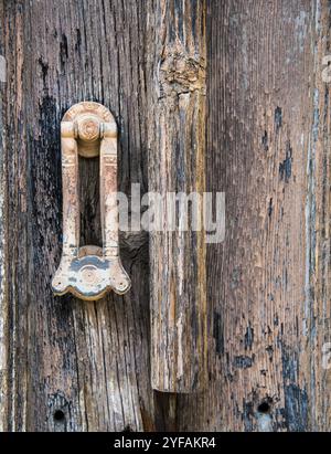 Vintage-Türgriff aus Metall an einer alten geschlossenen Holztür Stockfoto