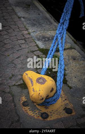 Details zum gelben Dock-Anlegestock aus Metall mit Seil zur Sicherung von Fischerbooten Stockfoto