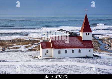 Die malerische Vik i Myrdal Kirche auf dem Gipfel des Hügels bietet malerische Bilder des atlantischen Ozeans und des Dorfes vik in Island Stockfoto