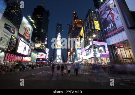 New York City, USA, 20. Juli 2011: New York Times Square mit Menschen, die am späten Abend spazieren gehen und bauen, mit Neonschildern in New York City, Norden Stockfoto