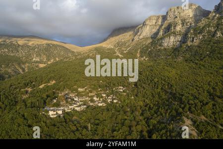 Drohnenlandschaft mikro Papingo Dorf, Zagorochoria Gegend, Epirus, Ioannina Griechenland. Astraka Turm felsige Klippen über dem Dorf bei Sonnenuntergang Stockfoto