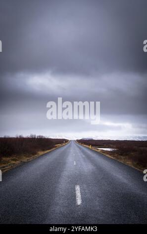 Landstraße auf der Autobahn gerade, leere Straße, die zu den verschneiten Bergen auf der Snaefelness-Halbinsel in Island führt Stockfoto